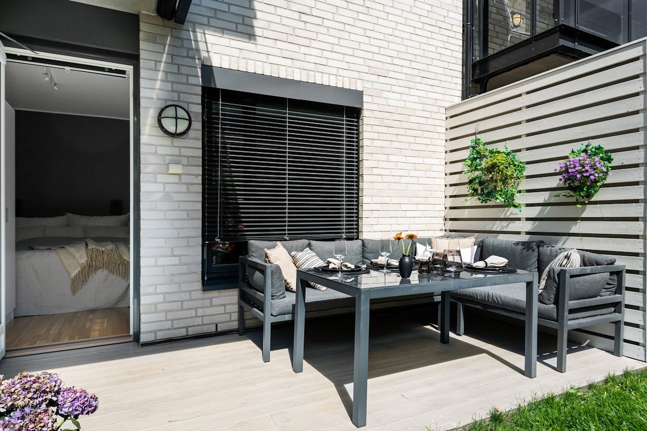 Contemporary terrace featuring stylish furniture and lush greenery, ideal for summer relaxation.