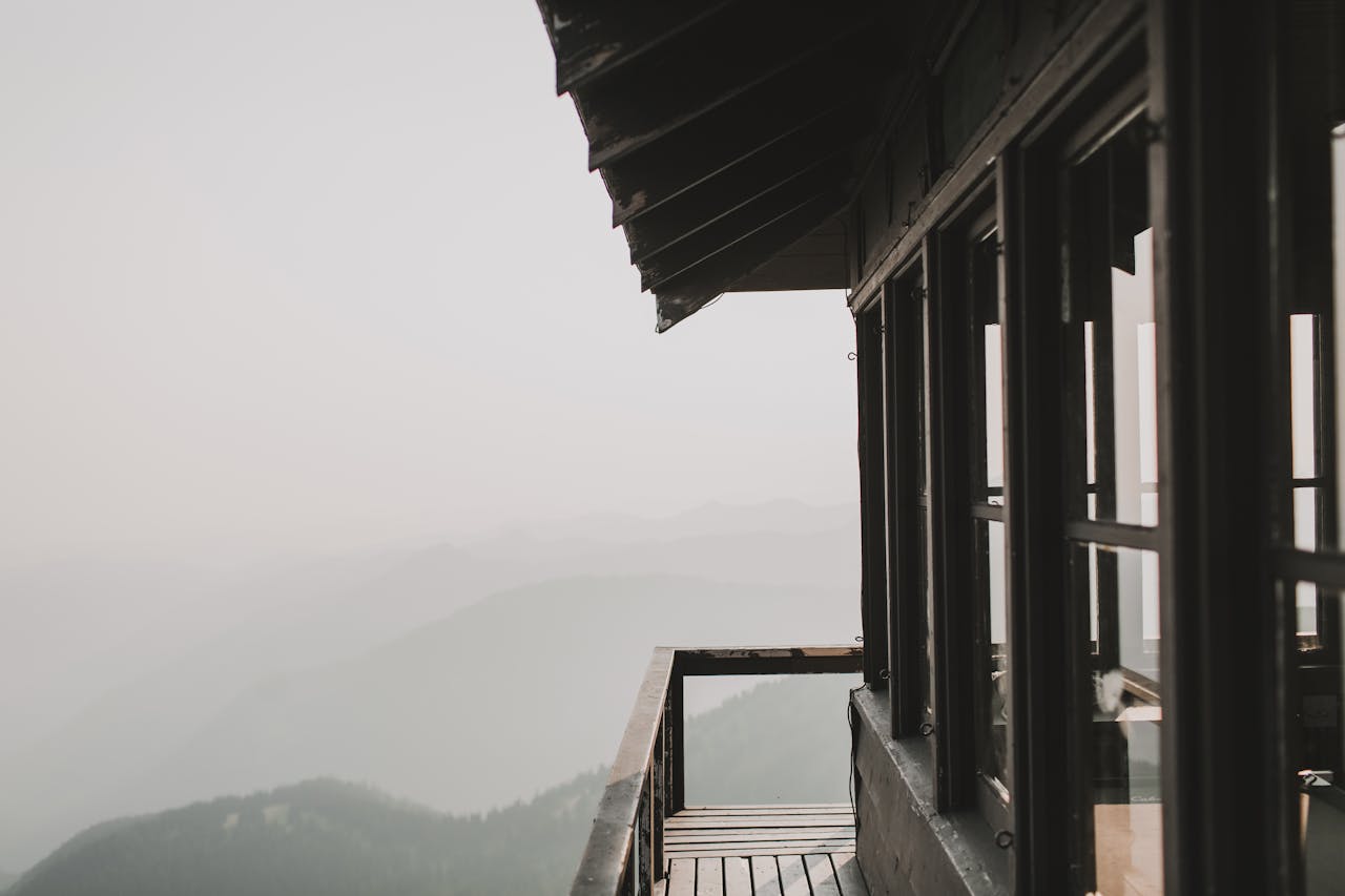 Experience the serene beauty of a mountain view from a rustic wooden lookout at sunrise.