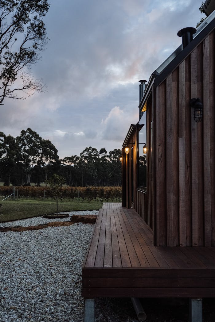 Charming wooden cabin surrounded by nature under an overcast sky during twilight.